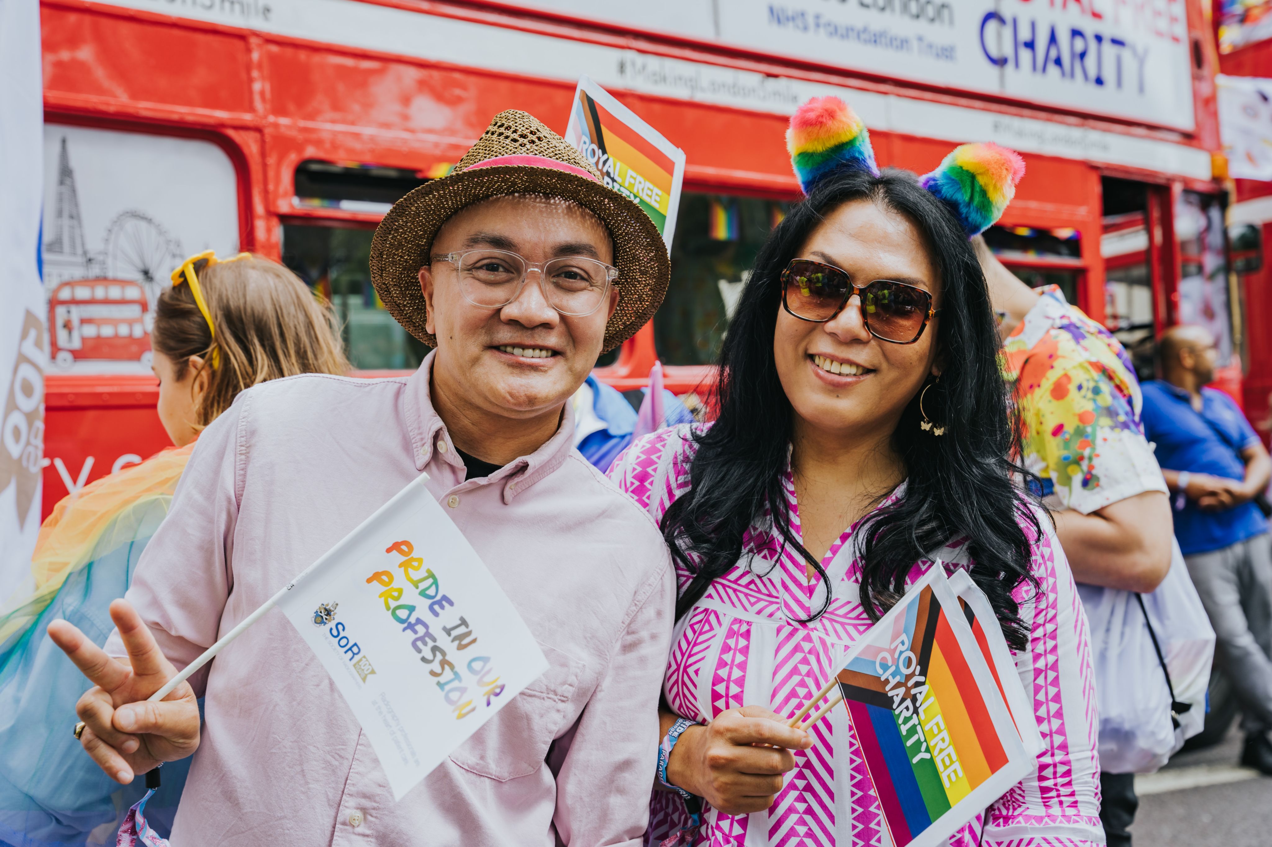 Two people holding small pride support flags